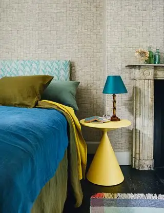 חדר שינה עם טפט ניטרלי ומצעים צבעוניים