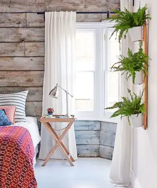Soveromsideer for tenåringer med rustikke gråvaskede trepaneler, stueplanter og rødmønstret sengekast.