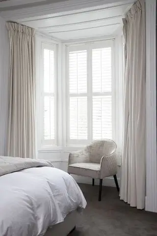 커튼과 셔터가 있는 흰색 침실