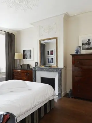 Soverom vender mot peis med speil over peishylle, som viser hvordan du får et lite soverom til å se større ut.