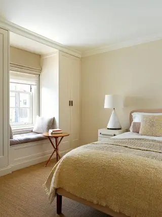 Chambre beige avec un siège de fenêtre conçue par Thurstan