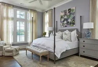 Et eksempel på hvordan du designer et soverom som viser et soverom med himmelseng, tregulv og et teppe