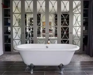 거울문이 달린 대형 옷장, 카펫과 나무 바닥이 혼합된 침실의 롤탑 흰색 욕조