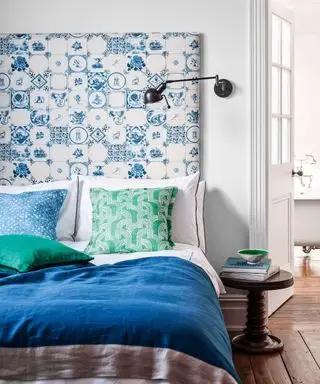 Un exemple d'idées de chambre d'amis montrant un lit bleu avec une tête de lit à motifs bleus et blancs