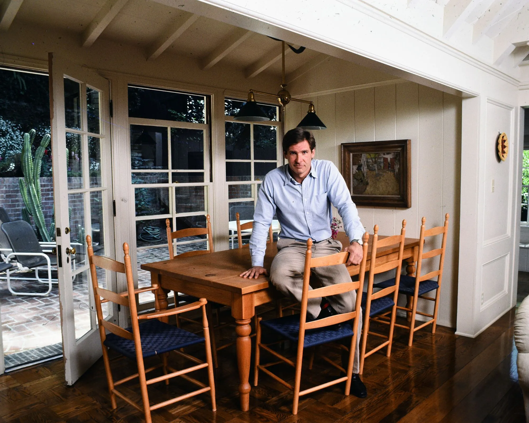 Harrison Ford so svojím dreveným stolom a stoličkami' loading='lazy' title=