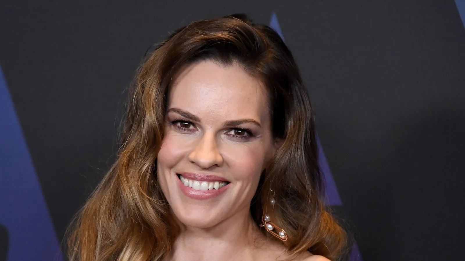 Hilary Swank sur fond noir et bleu' loading='lazy' title=