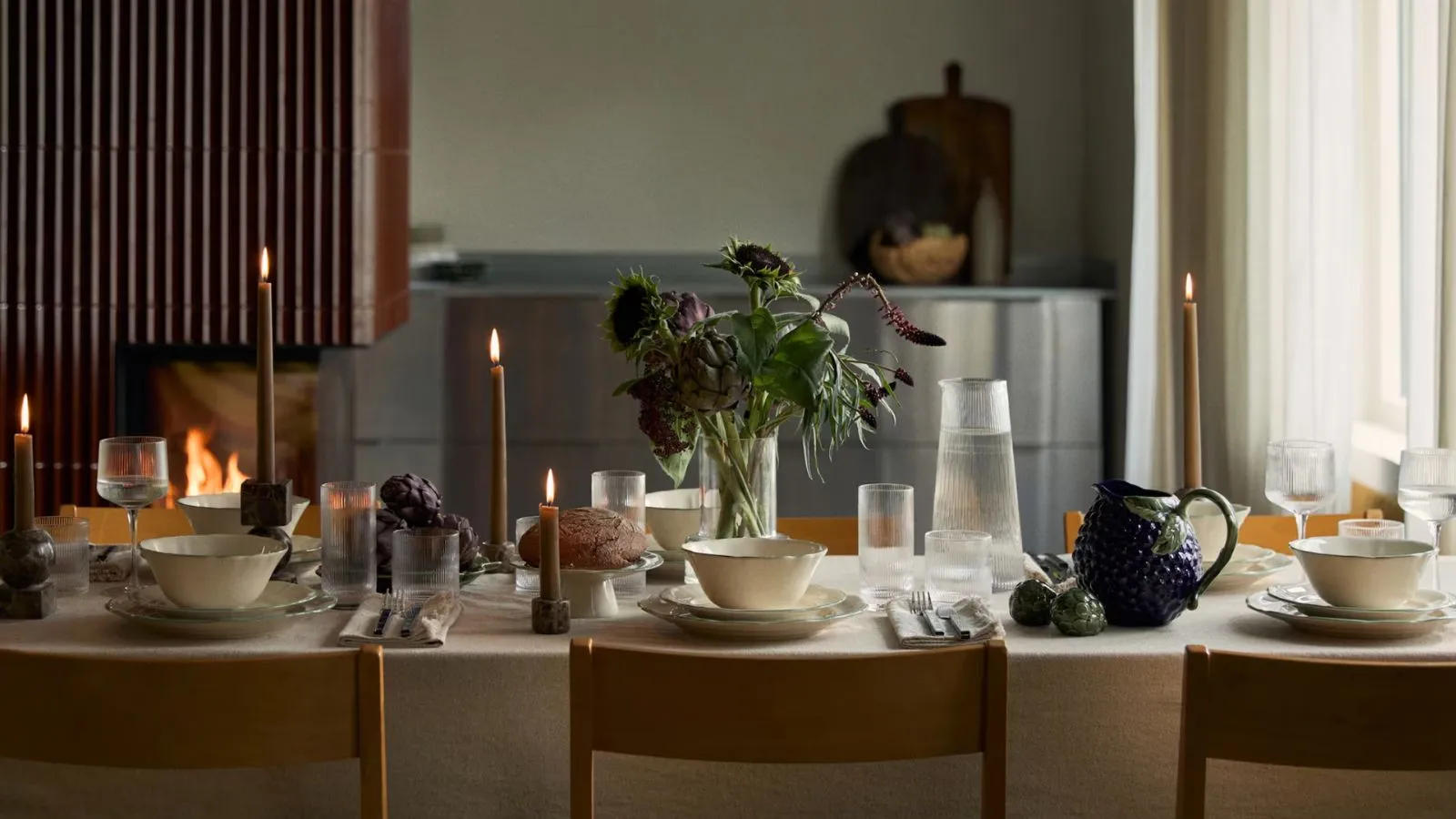 Jesenné prestieranie s bielym obrusom, bielym riadom a servírovacími miskami v tvare hrozna a artičokov' loading='lazy' title=