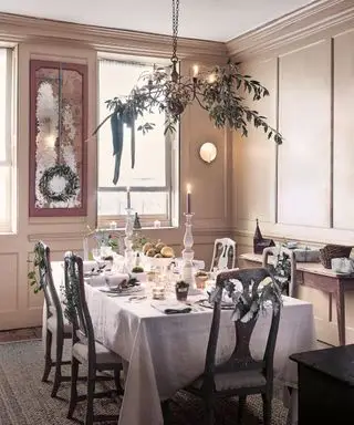 Salle à manger décorée de décorations de Noël, guirlande suspendue au-dessus de la table à manger