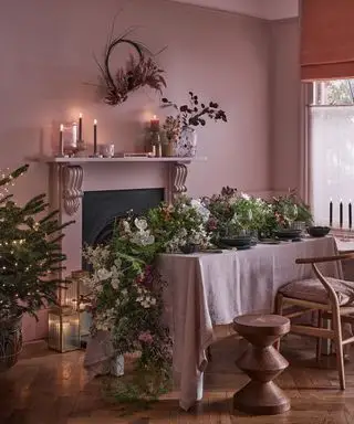 Salle à manger rose avec grande guirlande de table et décorations de Noël