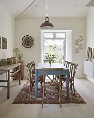 Salle à manger neutre avec table et chaises en bois et tapis nomade à motifs de Weaver Green