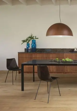 Salle à manger blanche avec suspension industrielle surdimensionnée par Ligne Roset