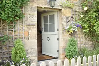 grønn stalldør i steinhytte