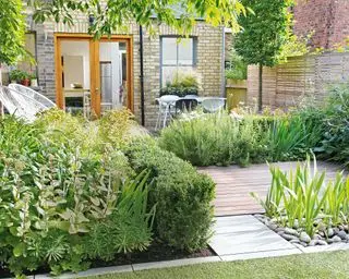 terrasse en bois avec zones plantées et bordure en pierre