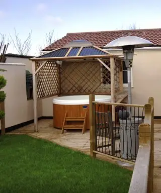 drewniana wanna z hydromasażem w małym ogrodzie