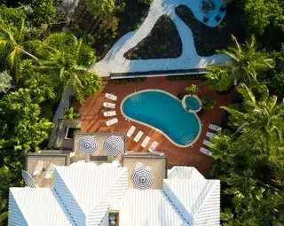 פטיו בריכה עם שמשיות וכיסאות נוח