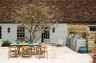 Venkovní kuchyňský kout s grilem, jídelním stolem a židlemi