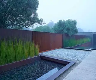 Une cour avant moderne avec un portail en métal conçu par SurfaceDesign Inc.