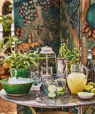 유리 제품과 얼음 그릇이 놓인 원형 테이블을 가까이서 보여주는 야외 식사 아이디어의 예