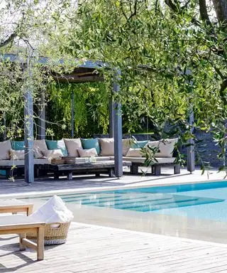 보호된 파티오 공간과 대형 야외 소파가 있는 수영장 공간