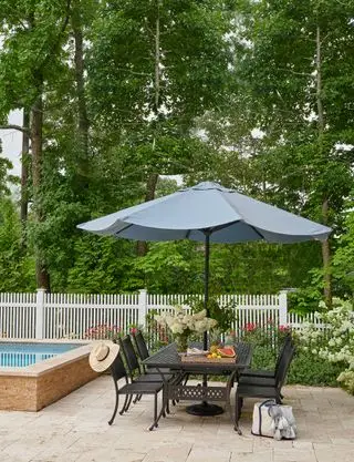 Terrasse mit Tisch und Stühlen im Freien neben dem Pool