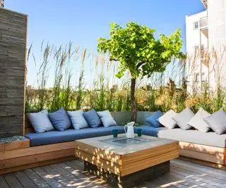 coin salon extérieur sur un balcon protégé par des graminées ornementales