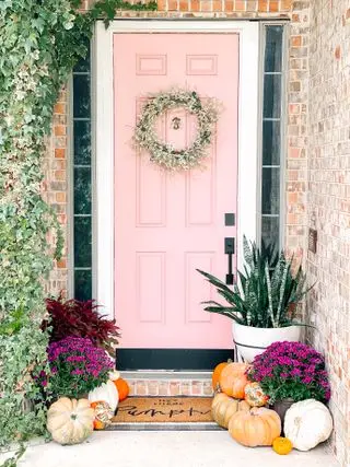 décor de porte d'entrée d'automne, porte rose avec couronne et citrouilles