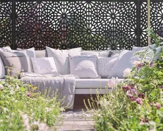 Garten mit Sofa und Paravent davor