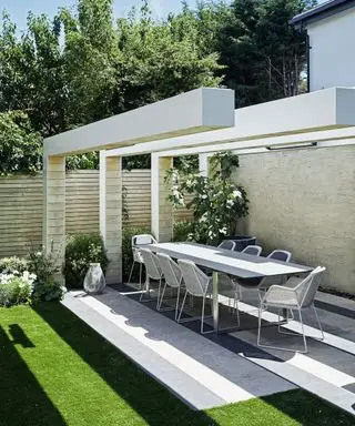 Ein Beispiel für Gartenschattenideen, das einen modernen Essbereich im Freien mit einem Tisch und Stühlen unter einer Pergola zeigt