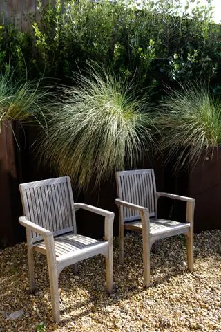 Gräser, die in Hochbeeten in einem Kiesgarten an der Küste gepflanzt wurden