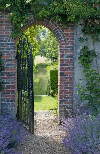 Portão de metal em parede de tijolos arqueados