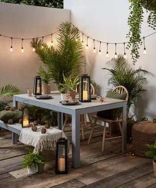 Patio de cour avec guirlandes lumineuses accrochées aux murs peints en blanc