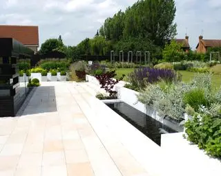 עיצוב פטיו עם תכונת מים בסכמת גינה אלגנטית ומודרנית.