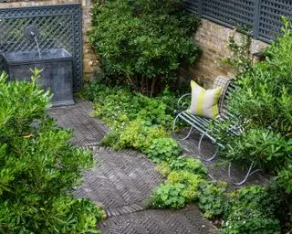 עיצוב פטיו באופן סימפטי לארכיטקטורה שמסביב, מודגם עם ריצוף לבנים כהות אדרה בסכימה בהשראה תעשייתית.