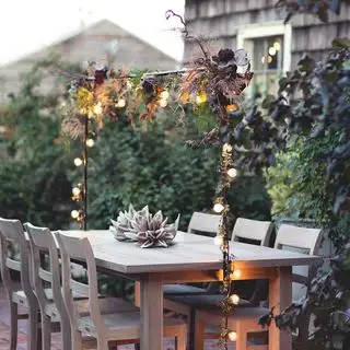 table à manger extérieure avec guirlande lumineuse sur le dessus
