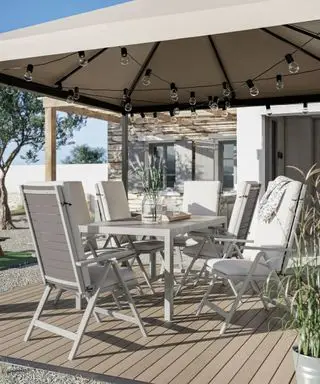 gazebo avec éclairage à guirlande et salon de jardin