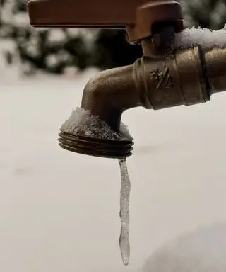 수도꼭지 끝에 고드름 모양으로 얼어붙은 소량의 물