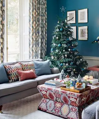 Salon bleu avec sapin de Noël et canapé