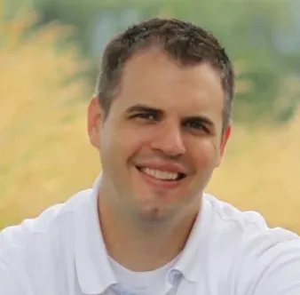 白いシャツを着た、髪を短く刈った男性の専門家の顔写真。' loading='lazy' title=