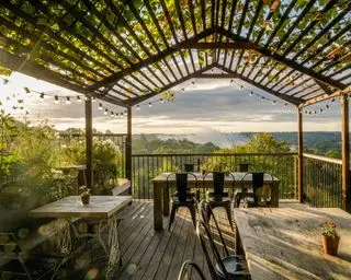 Holzpergola über einem Balkon mit Blick auf die Landschaft