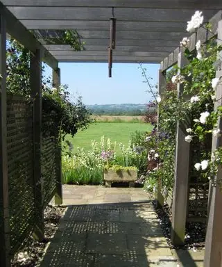Holzpergola, die den Blick auf die umliegende Landschaft umrahmt