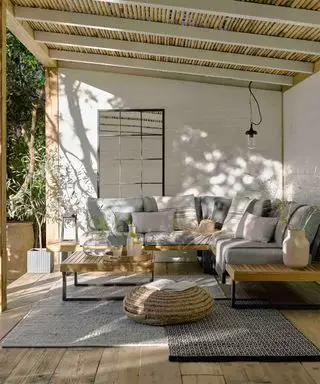 überdachte Holzterrasse mit Möbeln und Pendelleuchte