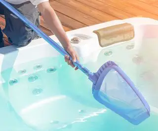 温水浴槽の水をすくう