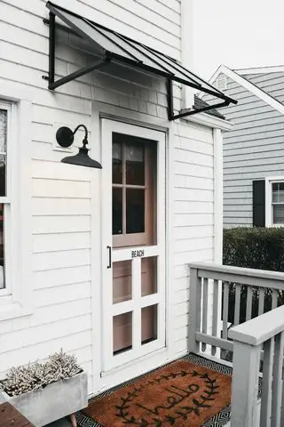 auvent noir sur une maison blanche