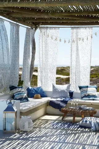 pergola avec toit en roseaux et côtés en rideaux