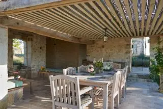 pergola couverte avec poutres et bâtons et espace pour manger en plein air