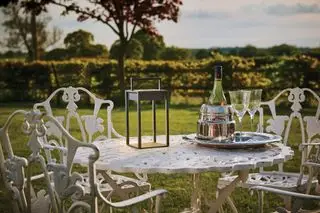 lanterna solare su un tavolo da esterno in metallo bianco circondato da sedie