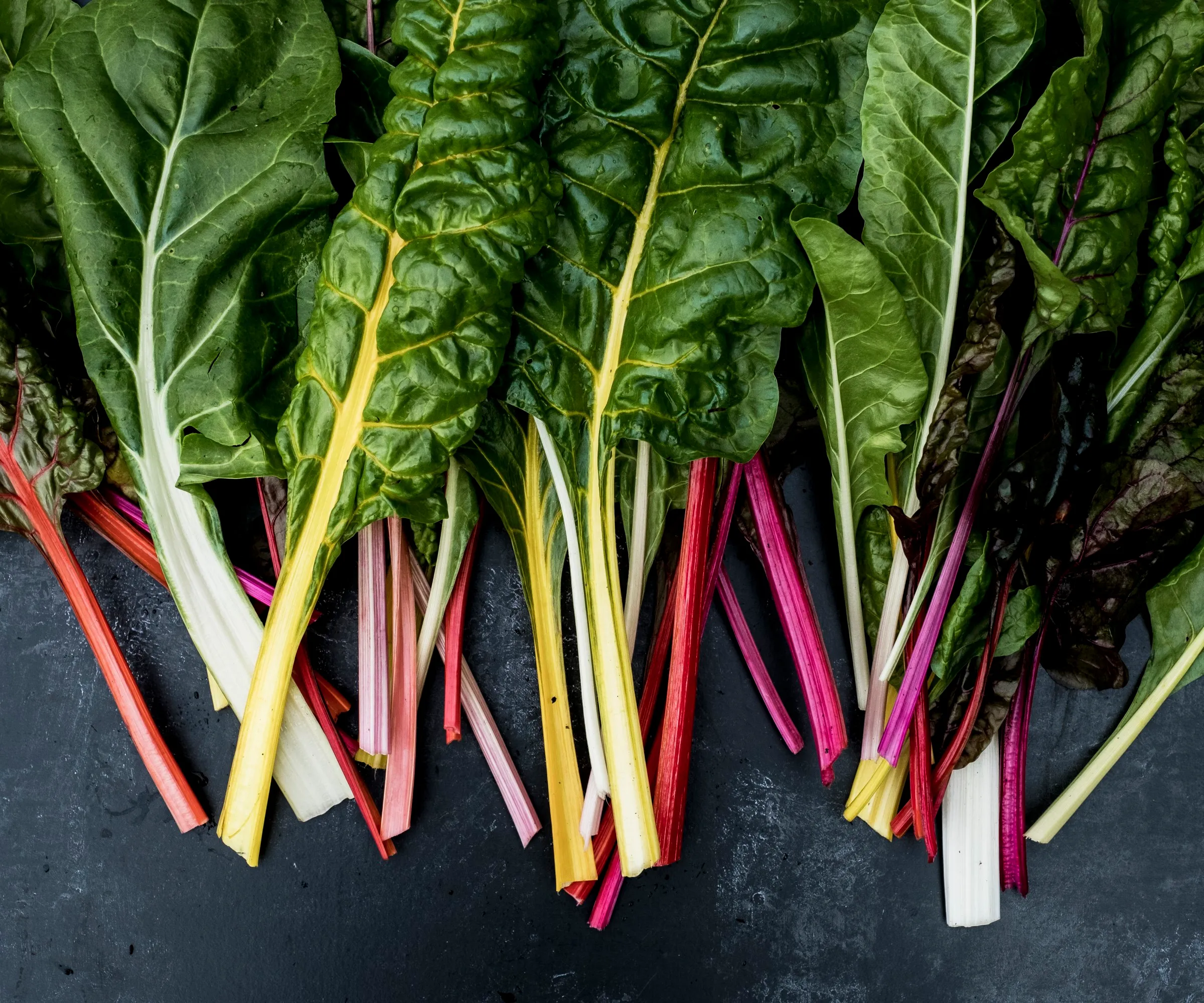 Una gama de hojas de acelgas de colores.' loading='lazy' title=