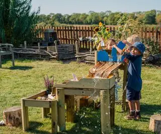 deti hrajúce sa na drevenom vodnom stole na dvore