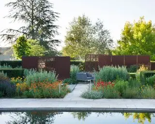 Mamparas de acero corten en jardín junto a zona de piscina