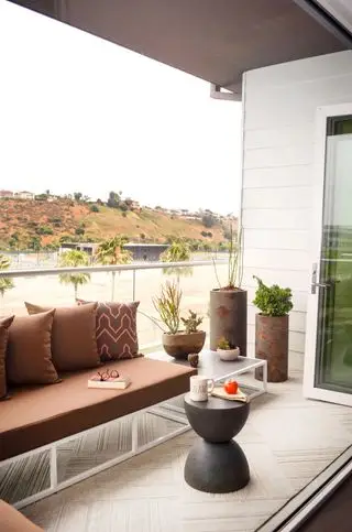 Mały balkon z narożnymi siedzeniami i poduszkami